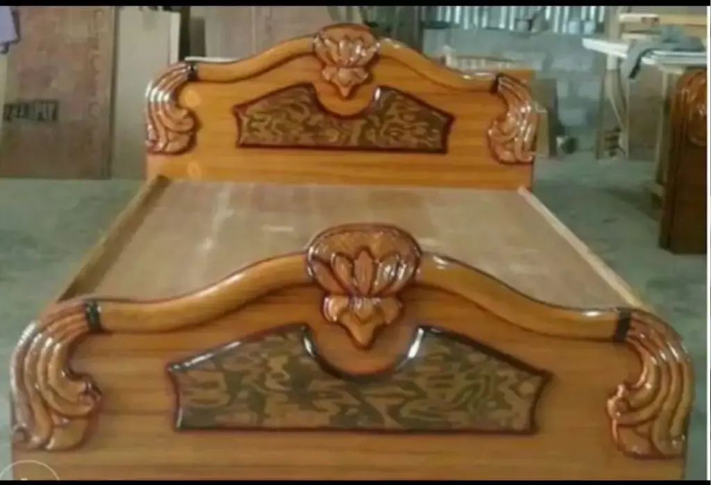 Ornate wooden bed with decorative headboard and footboard